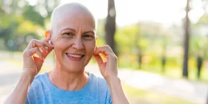 Paciente oncológica sonriente manteniendo una buena salud oral y bienestar durante su tratamiento.
