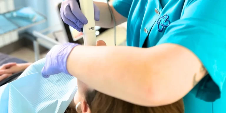 Dentista de OHI realizando exploración con escáner intraoral a paciente en clínica dental hospitalaria Madrid